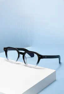 Detail of round gradient black to clear frames with metal rivets on blue background