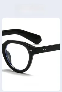 Close-up of black full-rim sunglasses featuring double silver rivets and light blue lenses