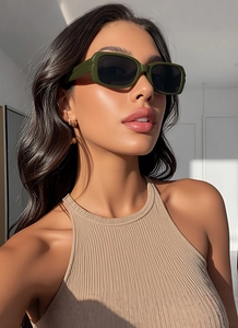 Chic olive green rectangle sunglasses with dark lenses on model in natural light
