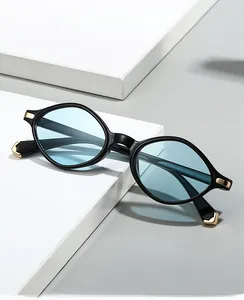 Détail de lunettes de soleil triangle 2025 avec verres bleus et accents dorés en métal