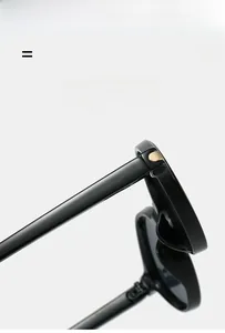 Détail de la charnière en métal doré sur lunettes de soleil noires triangulaires