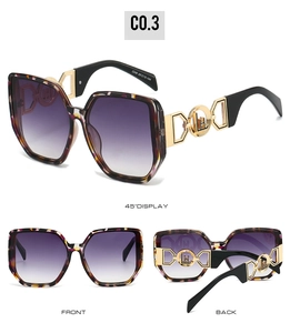 Detail view of oversized polygon sunglasses with purple gradient lenses and gold metal hinges