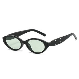Fashionable black oval cat-eye sunglasses with light green lenses and side stitch detail