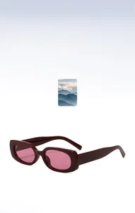 Detail of dark red jelly frame sunglasses with translucent pink lenses in a sleek oval shape