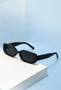 Macro shot of stylish black narrow rectangle sunglasses on a minimalist white stand