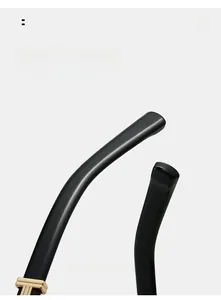 Détail macro de branches de lunettes noires courbées avec incrustation en T dorée