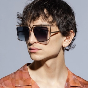 Close-up of luxury square gold metal sunglasses with gradient lenses and V-shaped bridge