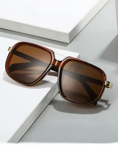 Detail view of large square PC frame sunglasses with metal hinges and dark brown lenses
