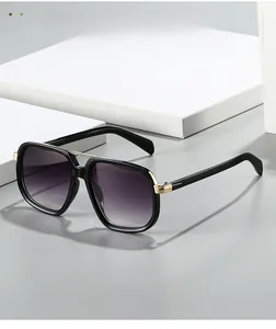 Detail of oversized pilot sunglasses with gold metal bridge and gradient purple lenses