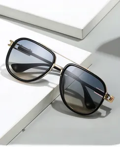 Detail of stylish oversized glasses with black frame, gold metal bridge and blue gradient lens