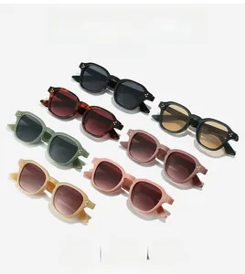 Dettaglio flat lay di occhiali da sole ovali vintage in sette colori con rivetti metallici