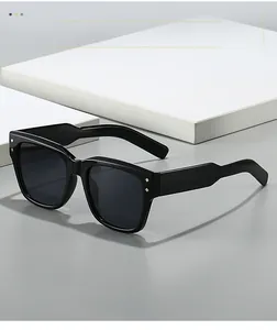 Detail view of square black sunglasses featuring golden diamond rivets on the frame temples