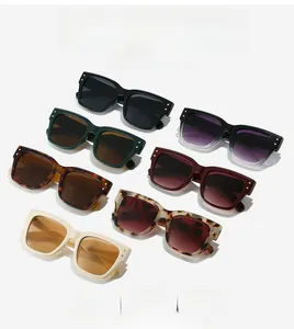 Close-up of retro square sunglasses featuring thick frames and metal diamond rivets