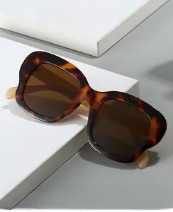 Détail de lunettes de soleil oversize écaille de tortue avec verres marron sur support