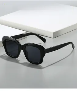 Gros plan de lunettes de soleil noires à monture épaisse sur des supports géométriques