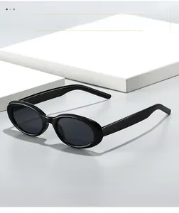 Detail view of oval retro sunglasses with black frames on white geometric props