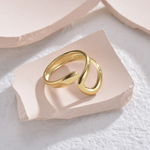 Minimalist gold-plated adjustable snake ring with polished finish on a modern display