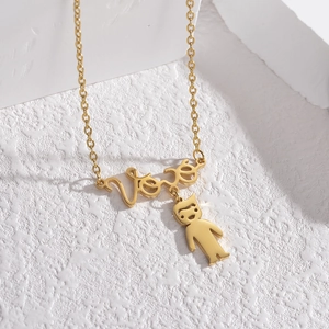Detail einer personalisierten Goldkette mit Vivi-Schriftzug und Jungen-Anhänger auf Stein