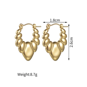 Détail des boucles d'oreilles cœur dorées avec texture ondulée, taille 1,8 cm sur 2,6 cm