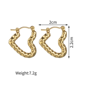 Détail de boucles d'oreilles cœur dorées à texture ondulée avec dimensions 2cm x 2,2cm