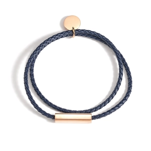 Détail du bracelet double en cuir tressé bleu marine avec fermoir en or rose poli