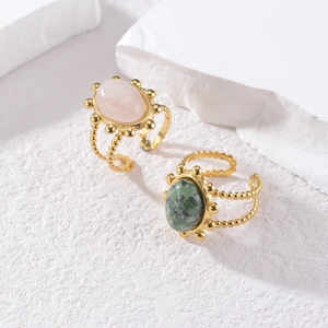 Golden stackable ring set with pink and green oval gemstones on beaded textured bands
