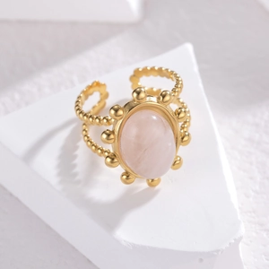 Detailed macro view of an adjustable gold ring featuring an oval pink quartz gemstone