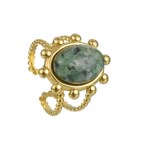 Macro shot of a vintage gold-beaded adjustable ring with an oval green natural stone inlay