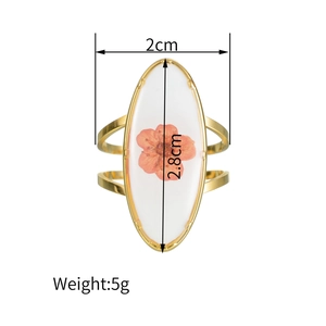 Vue détaillée d'une bague ovale avec fleur séchée et dimensions de 2,8 cm sur 2 cm