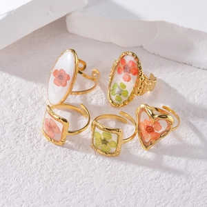 Ensemble de cinq bagues en acier doré avec de véritables fleurs séchées en résine