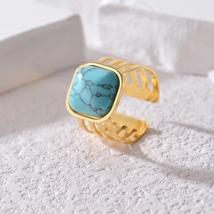 Gold-plated turquoise ring with three-row hollow band on white stone background