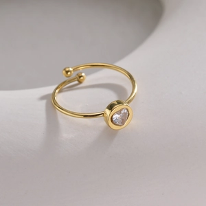 Bague coeur en zircon doré sur support en céramique blanche avec lumière douce