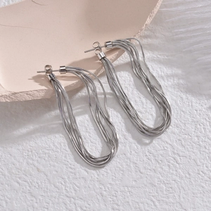 Elegant multi-layer silver snake chain earrings on a minimalist ceramic display