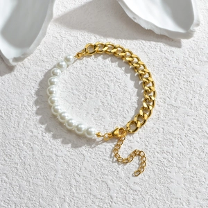 Détail du bracelet en perles et chaîne gourmette dorée avec fermoir mousqueton robuste