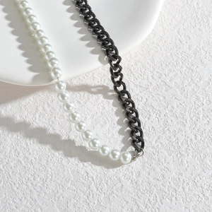Collier minimaliste en acier inoxydable et perles sur un plateau en céramique blanc