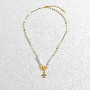 Détail du collier à perles avec pendentif avion doré et étiquette S.Steel