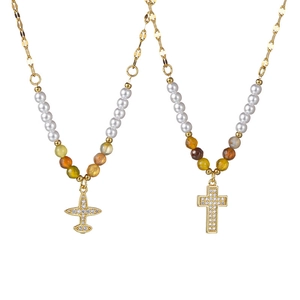 Ensemble collier perlé doré avec pendentifs avion et croix en zircone sur fond blanc