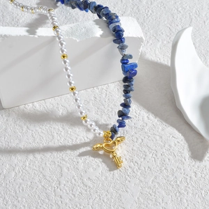 Lapis lazuli and pearl necklace with golden winged heart key pendant on white stone