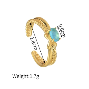 Dettaglio dell'anello dorato con dimensioni: diametro 1,8 cm e zircone blu da 0,6 cm