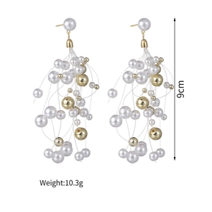 Detail view of 9cm beaded tassel earrings featuring gold metal and white faux pearls