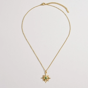 Gold starburst pendant necklace featuring a central green stone on an adjustable chain