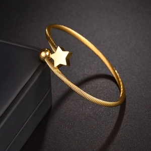 Macro detail of golden cable twist star bracelet with polished sphere on jewelry box