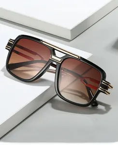 Macro detail of square oversized sunglasses with gold bridge and brown gradient lenses