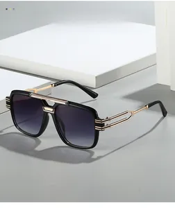 Detail of square black and gold sunglasses with textured metal temples and purple gradient lenses