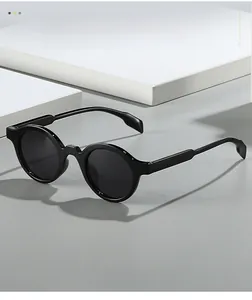 Close-up of retro round black sunglasses on geometric blocks showing texture material