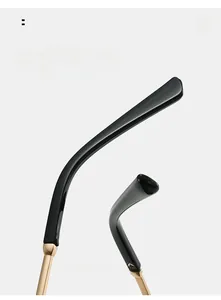 Detail view of glossy black curved temple tips with premium gold metal hinge accents