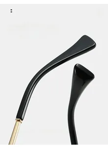 Detail of curved black mirror legs with golden metal hinges for comfortable wear
