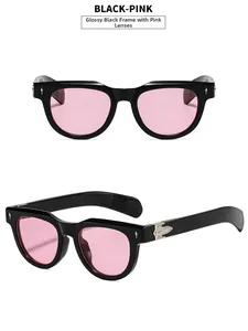 Detail of glossy black square sunglasses with pink lenses and silver metal hinges