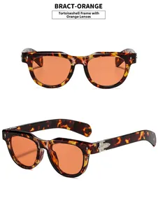 Detail view of tortoiseshell frame sunglasses with orange lenses and silver floral hinges