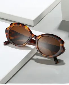 Detailed view of tortoiseshell oval cat-eye sunglasses on a white geometric platform
